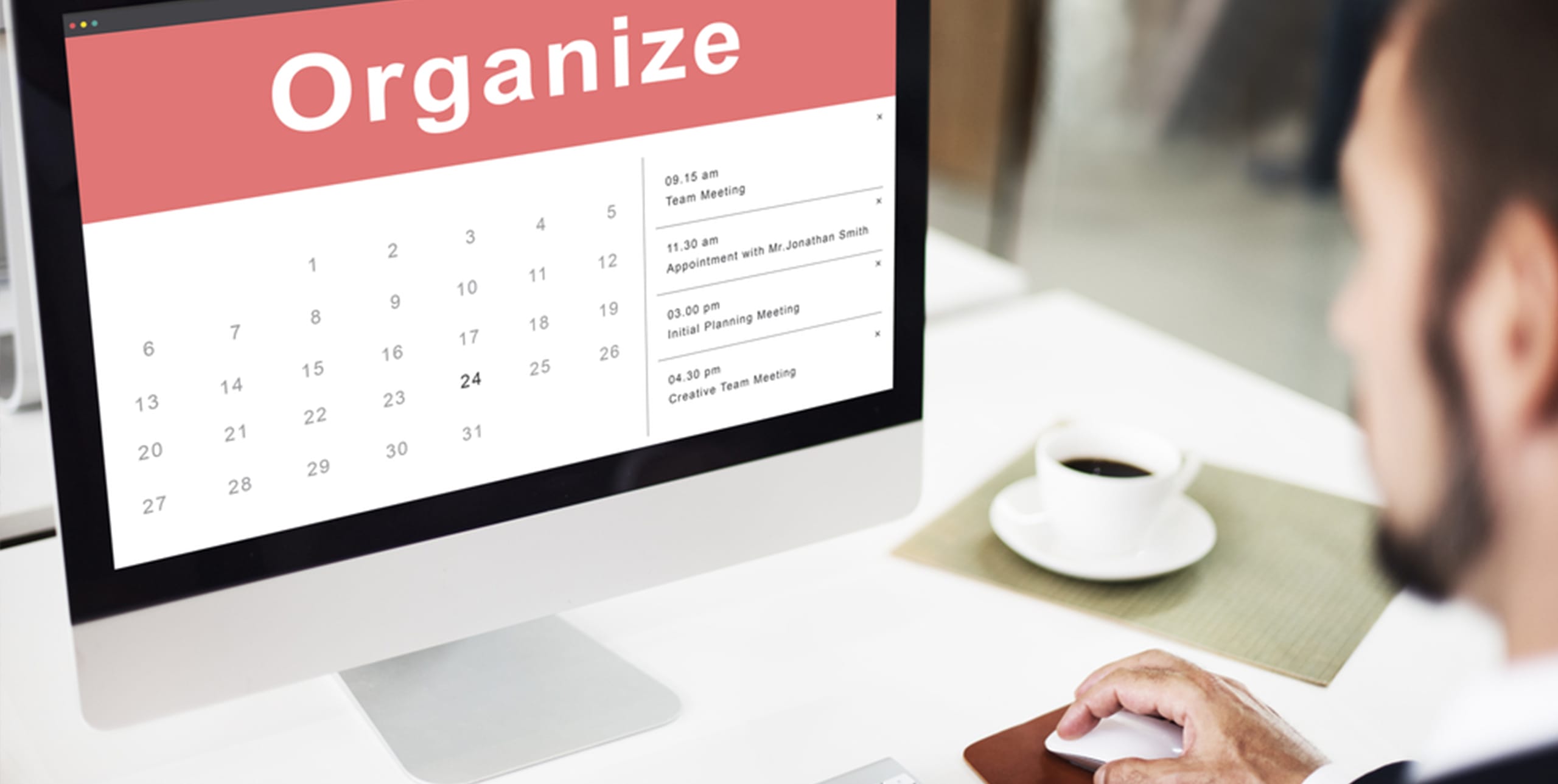 Un bărbat se uită la un calendar digital pe un computer cu textul "Organizare" și întâlniri enumerate.