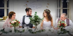 un mire si o mireasa stau cu familia lor la receptia nuntii.