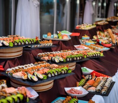 Bufet cu varietate de sushi, cu rulouri colorate și aranjamente atractive pe platouri, creând o masă îmbietoare.