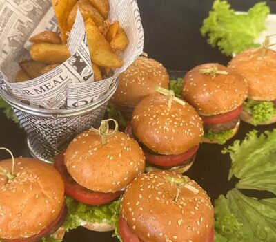 Mini burgeri gustoși cu cartofi tăiați în paner de ziar.