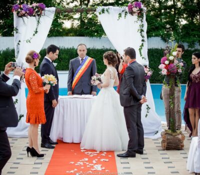 Nuntă în aer liber cu mire și mireasă, funcționar și invitați.