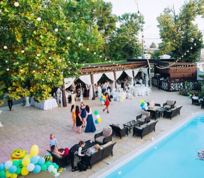 O vedere aeriană a evenimentului în aer liber la Azare cu o piscină, lumini și invitați.