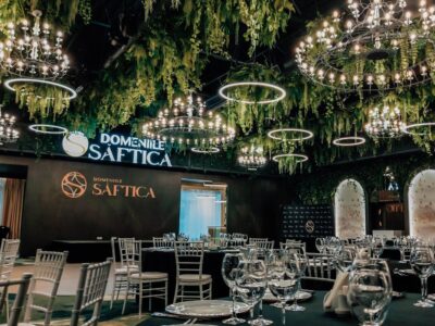 Interiorul Domnie Saftica cu candelabre, verdeață și mese aranjate.