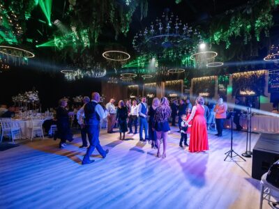 Oamenii se bucură și dansează pe ringul de dans într-o sală de bal decorată.