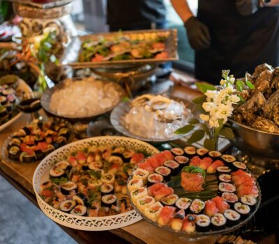 O selecție generoasă de sushi, stridii și salate pe masă.