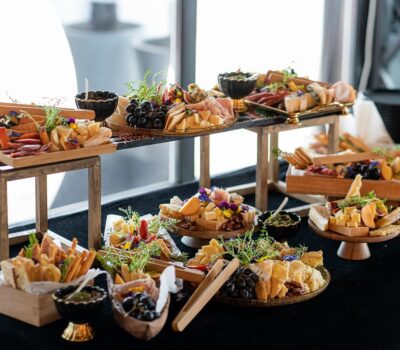 Diverse sortimente de brânzeturi, fructe și carne pe platouri elegante, pentru un eveniment culinar rafinat.