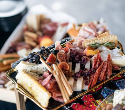 Platouri colorate de brânzeturi și charcuterie cu fructe și biscuiți.