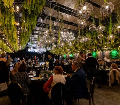 Oaspeți la mese cu lumini decorative și verdeață la o nuntă Domeniul Sarata.