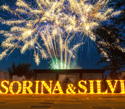 Numele iluminate „SORINA & SILVIU” și artificii pe timp de noapte.