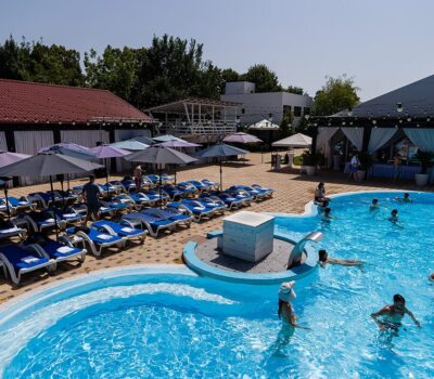 O vedere aeriană a zonei piscinei Aqua & Mari, cu șezlonguri și oameni care înoată în apă.