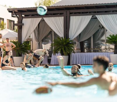 Oameni care se distrează într-o piscină în aer liber.