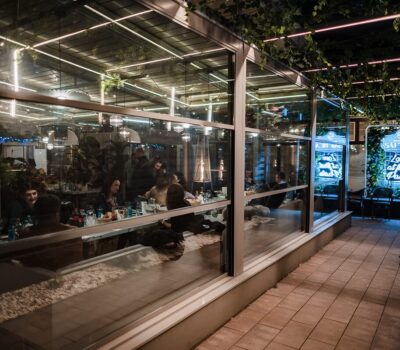 Exteriorul Saftica: pereți de sticlă, neon "Love at first pasta", oameni.