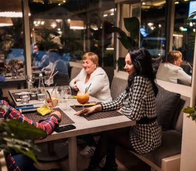 Oameni care beau băuturi la o masă într-un restaurant.