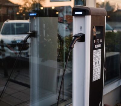 Două stații de încărcare auto electrice, conectate la o fereastră.