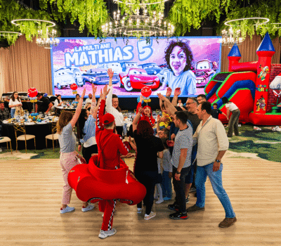 Interiorul unei petreceri cu animatori, o trambulină Mario Bros și un banner cu textul „La mulți ani! Mathias 5”.