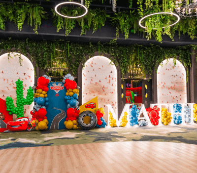 Decor Cars, cu baloane, cactus, pneuri. Numele "Mathias" umplut cu baloane. Verdeață deasupra arcadei, podea din lemn.