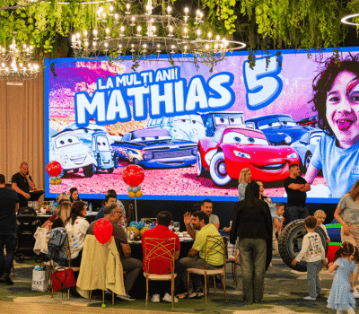 Petrecere aniversară pentru Mathias. Pe fundal, "La mulți ani! Mathias 5", cu imagini din Cars și un portret al lui Mathias.