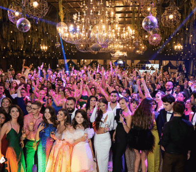 Oameni care se bucură la un eveniment cu paharele ridicate.